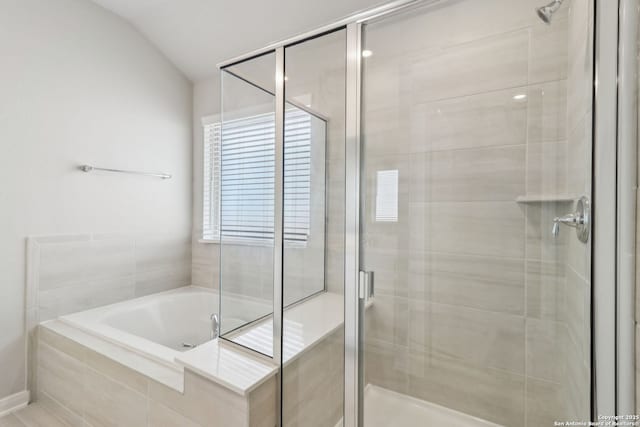 bathroom featuring a stall shower, lofted ceiling, and a garden tub