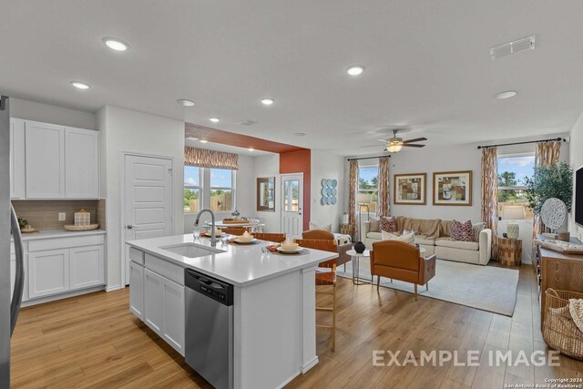 6879 Comanche Cave, San Antonio, TX 78247 - kitchen featuring sink, dishwasher, light hardwood / wood-style floors, an island with sink, and white cabinets