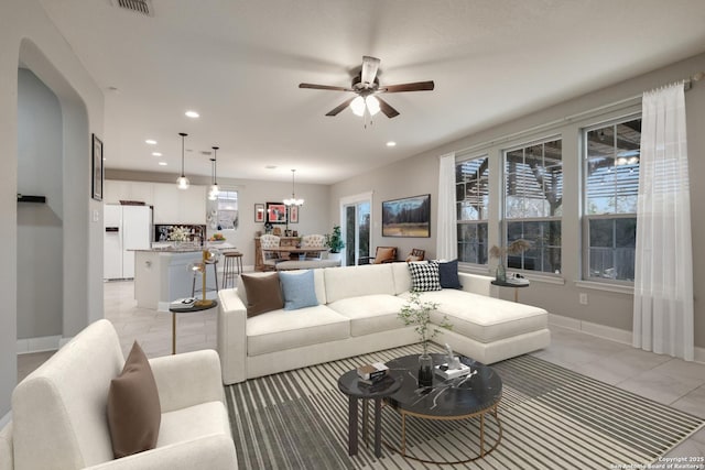 living room featuring ceiling fan with notable chandelier