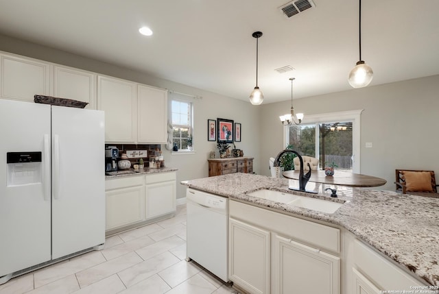 kitchen with white appliances, decorative light fixtures, sink, and white cabinets