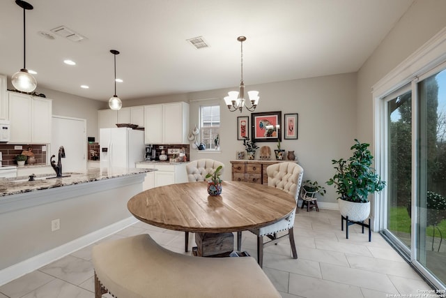 dining area with an inviting chandelier and sink