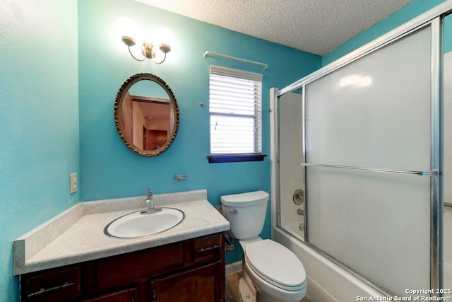 full bathroom featuring toilet, combined bath / shower with glass door, vanity, and a textured ceiling