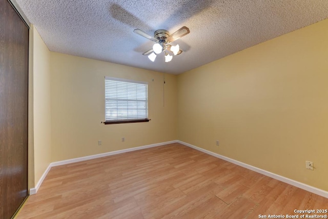 empty room with ceiling fan, a textured ceiling, and light hardwood / wood-style floors