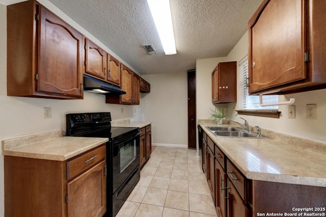 kitchen with light tile patterned flooring, sink, black appliances, and a textured ceiling