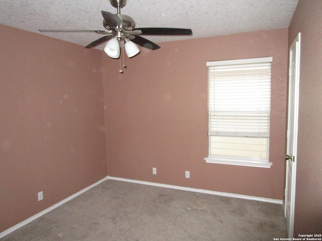 carpeted empty room with ceiling fan and a textured ceiling