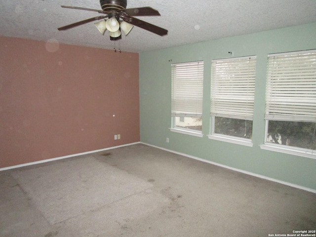 unfurnished room with ceiling fan, carpet floors, and a textured ceiling