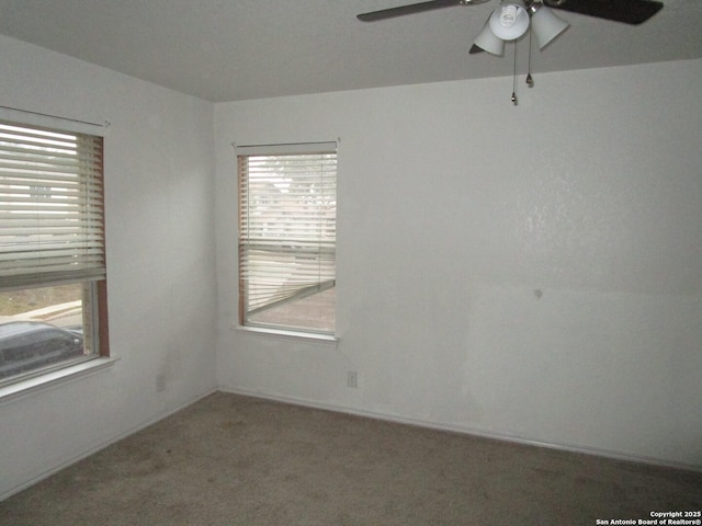 unfurnished room featuring ceiling fan and carpet