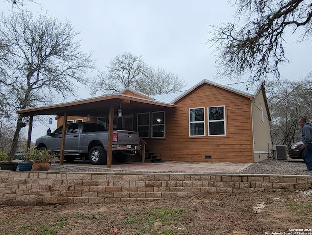 view of home's exterior with a carport and central AC unit