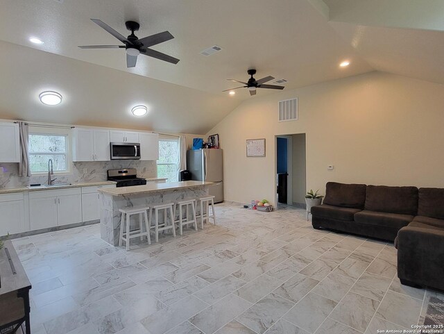 39 Post Oak Ln, Vernia, TX 78121 - kitchen featuring a breakfast bar, sink, white cabinetry, a center island, and appliances with stainless steel finishes