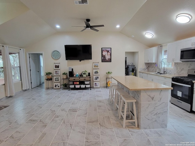 39 Post Oak Ln, Vernia, TX 78121 - kitchen featuring white cabinetry, lofted ceiling, sink, a center island, and stainless steel appliances