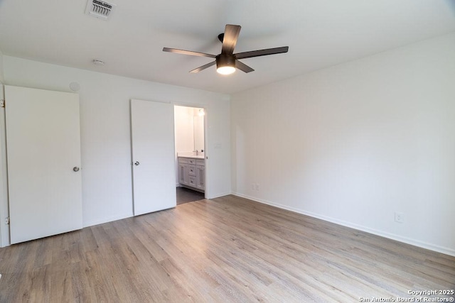 unfurnished bedroom featuring ceiling fan, ensuite bathroom, and light hardwood / wood-style floors