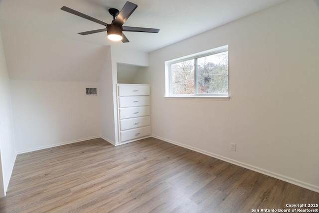 unfurnished bedroom with lofted ceiling, ceiling fan, and light wood-type flooring