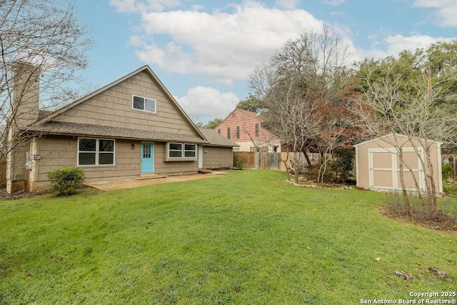 rear view of house featuring a yard and a storage shed