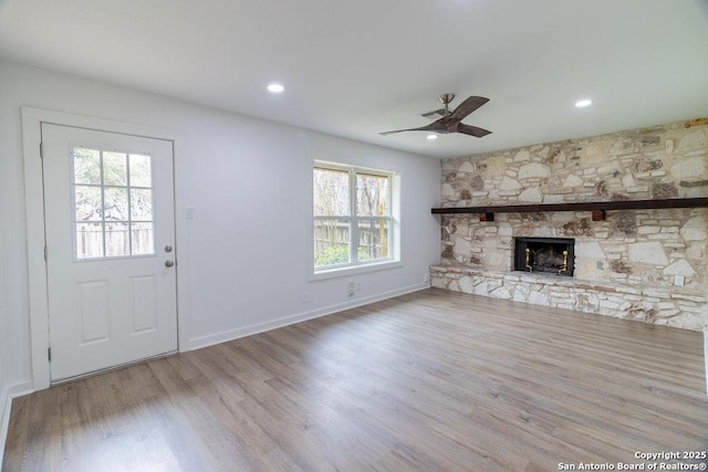 unfurnished living room with a fireplace, light hardwood / wood-style floors, and ceiling fan