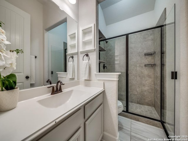 bathroom featuring vanity, toilet, and walk in shower