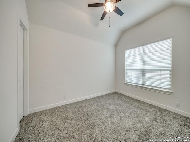 carpeted empty room with vaulted ceiling and ceiling fan