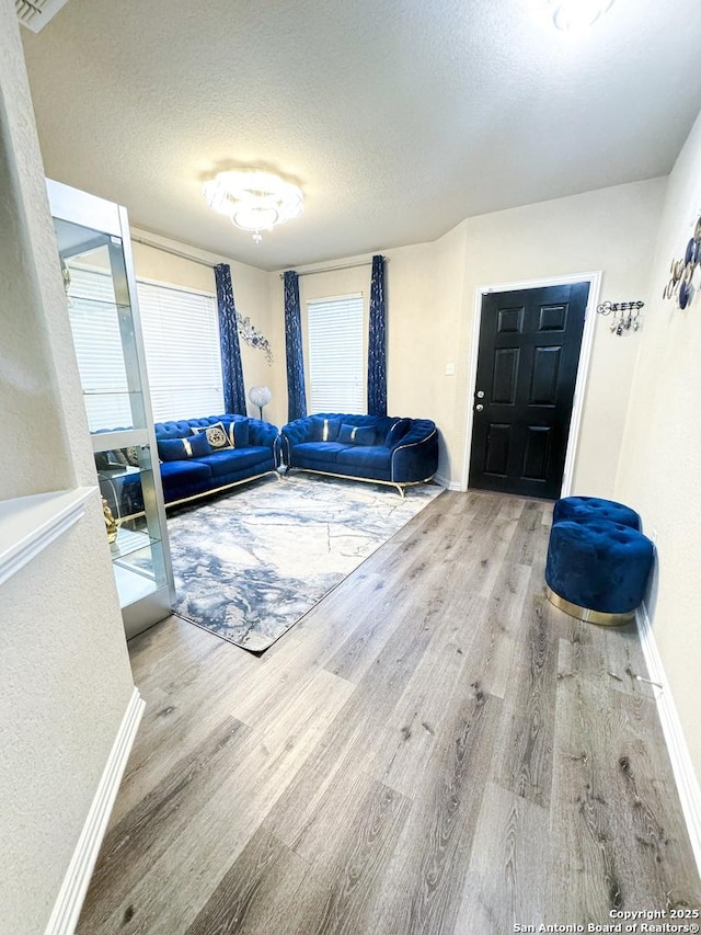 foyer entrance featuring hardwood / wood-style floors and a textured ceiling