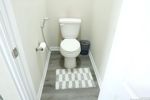 bathroom featuring wood-type flooring and toilet