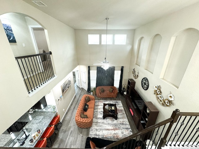 living room with hardwood / wood-style flooring and a towering ceiling