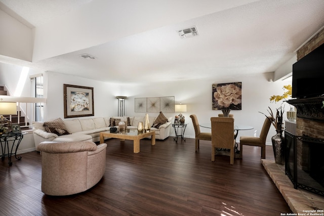 living room featuring dark hardwood / wood-style flooring and a brick fireplace