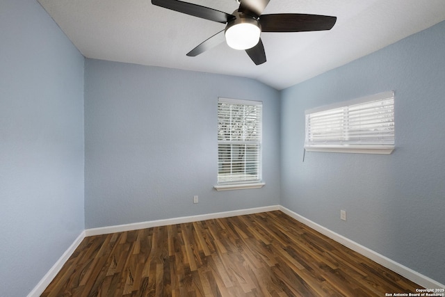 unfurnished room with a ceiling fan, dark wood-style flooring, vaulted ceiling, and baseboards