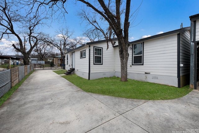 view of side of property featuring a yard, entry steps, crawl space, and fence