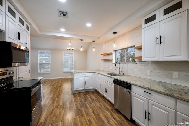 kitchen with pendant lighting, open shelves, appliances with stainless steel finishes, white cabinets, and a sink