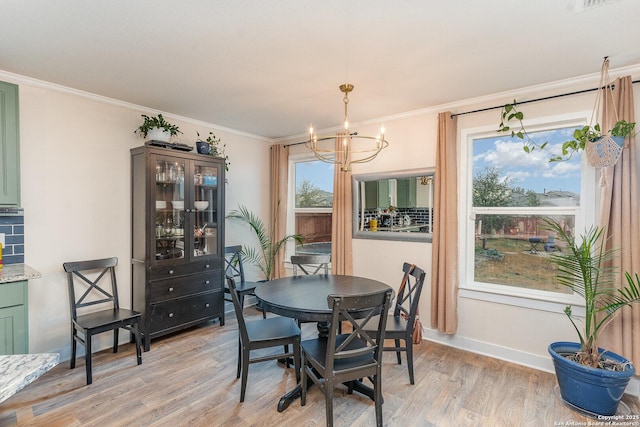 dining space featuring a notable chandelier, crown molding, and light hardwood / wood-style flooring