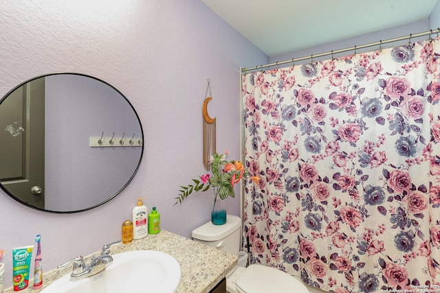 bathroom with vanity, curtained shower, and toilet