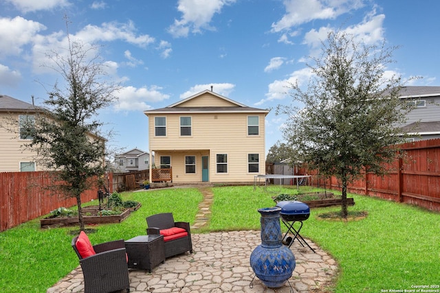 rear view of property with a yard, a patio, and a trampoline