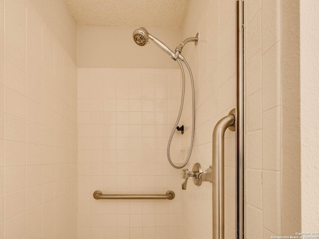 room details with tiled shower and a textured ceiling