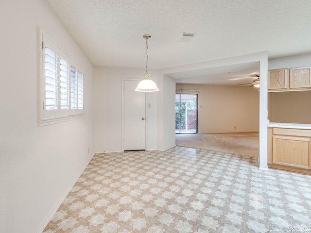 empty room with ceiling fan and a textured ceiling