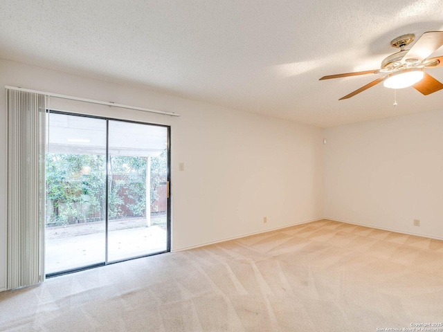 empty room with ceiling fan, light carpet, and a textured ceiling