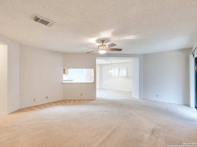 carpeted empty room featuring a textured ceiling and ceiling fan