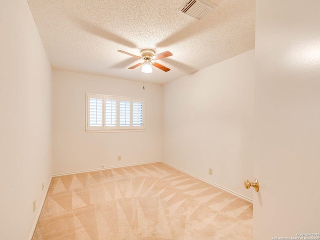 carpeted spare room featuring a textured ceiling and ceiling fan