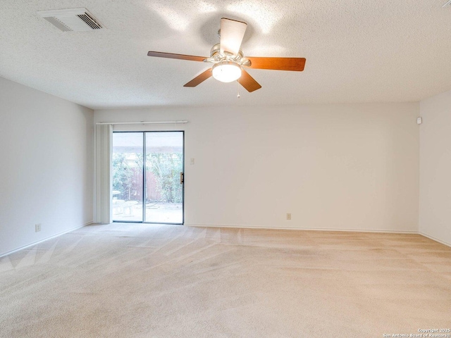 carpeted spare room featuring ceiling fan and a textured ceiling