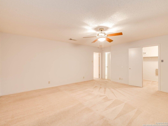 carpeted spare room with ceiling fan and a textured ceiling