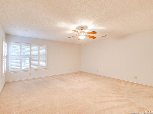 carpeted empty room with ceiling fan and a textured ceiling