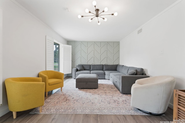 living room with an inviting chandelier, hardwood / wood-style flooring, and crown molding