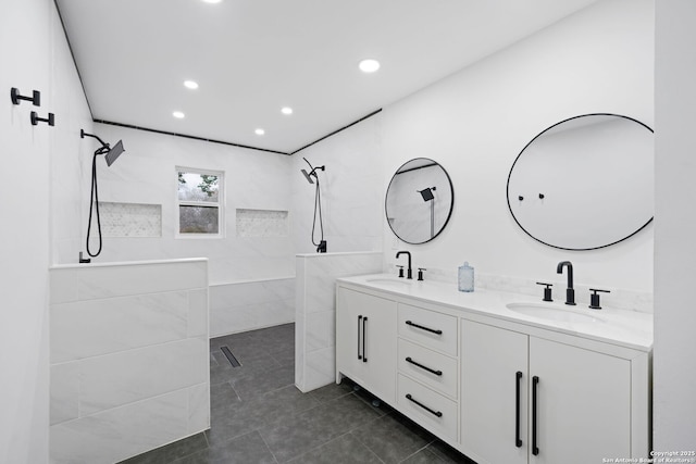 bathroom featuring tile patterned floors, vanity, and a tile shower