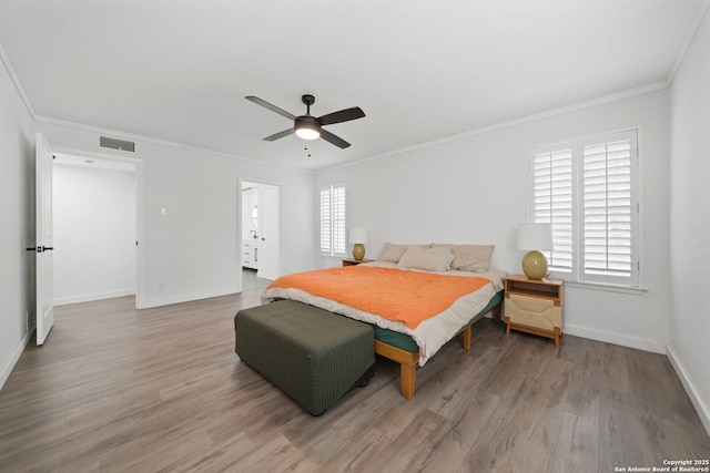 bedroom featuring hardwood / wood-style flooring, ornamental molding, and multiple windows