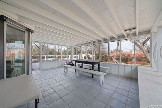 unfurnished sunroom featuring ceiling fan and beam ceiling