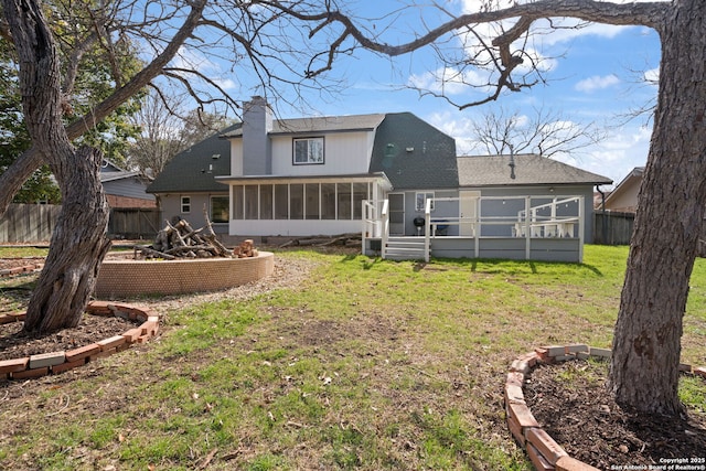 rear view of property featuring a sunroom and a lawn