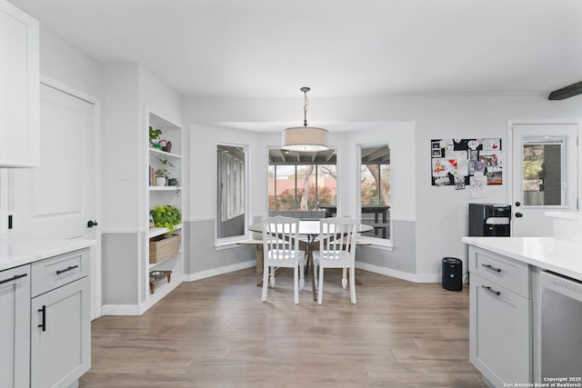 dining area featuring built in shelves and light wood-type flooring