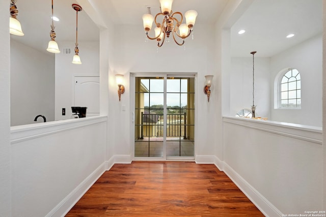 entryway featuring plenty of natural light, wood-type flooring, and a notable chandelier