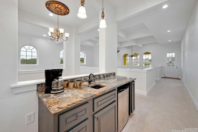 interior space with pendant lighting, light stone countertops, sink, and dishwasher