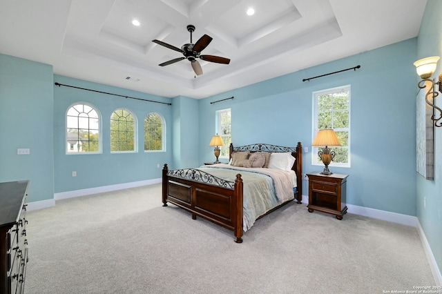 bedroom with multiple windows, light colored carpet, coffered ceiling, and ceiling fan