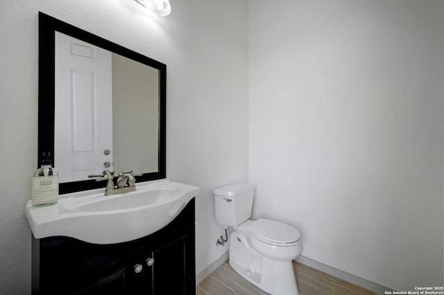 bathroom featuring vanity, hardwood / wood-style floors, and toilet