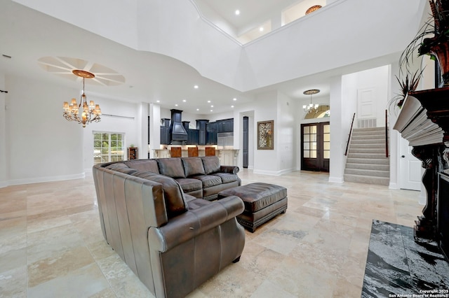 living room featuring a high ceiling, a chandelier, and french doors