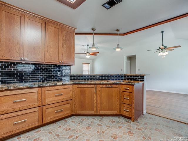 kitchen with lofted ceiling, backsplash, ceiling fan, and decorative light fixtures